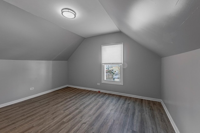 additional living space featuring lofted ceiling and dark hardwood / wood-style floors