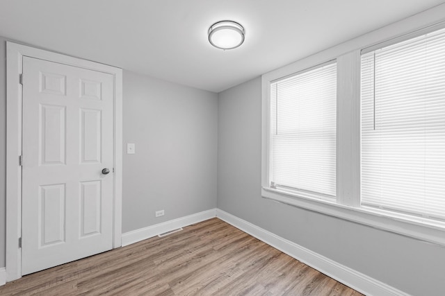 empty room with light hardwood / wood-style flooring