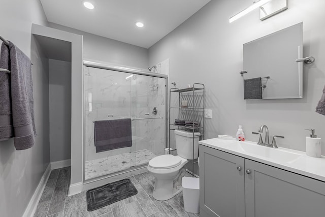 bathroom featuring toilet, walk in shower, and vanity