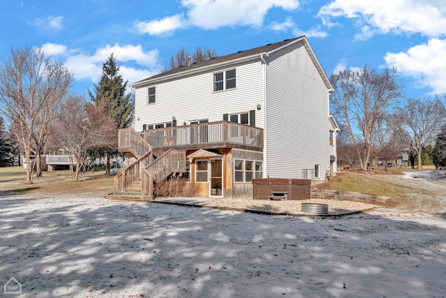 rear view of house featuring a deck and a hot tub