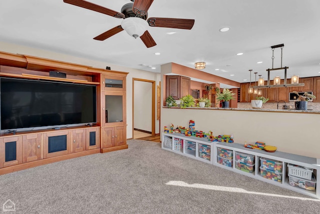 carpeted living room featuring sink and ceiling fan