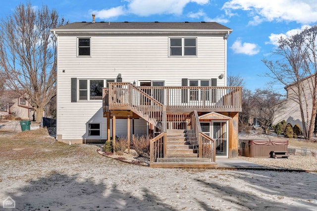 back of house with a deck and a hot tub