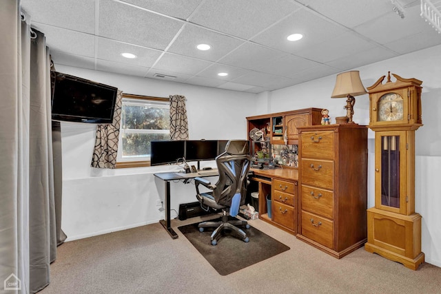 carpeted home office with a drop ceiling