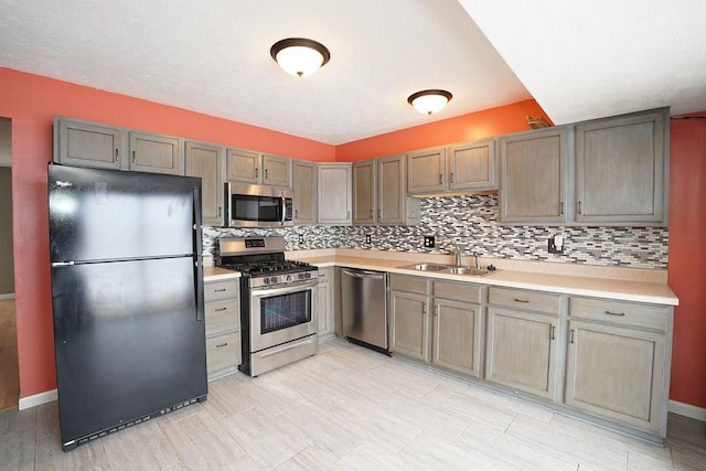 kitchen with sink, stainless steel appliances, and decorative backsplash