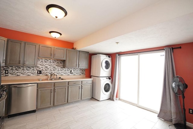 laundry area featuring sink and stacked washer / dryer