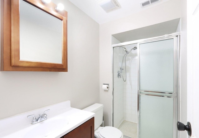 bathroom featuring vanity, toilet, and a shower with door