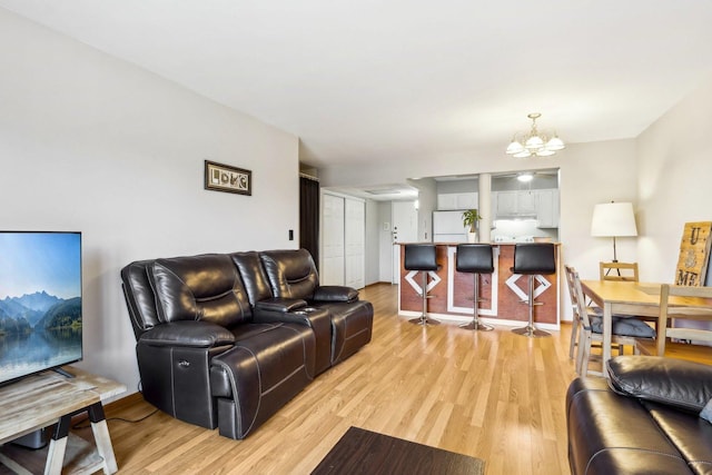 living room featuring a chandelier and light hardwood / wood-style floors