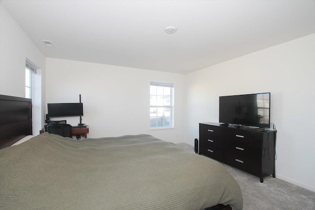 bedroom with multiple windows and light carpet