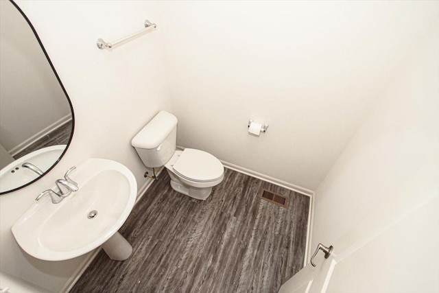 bathroom with sink, wood-type flooring, and toilet