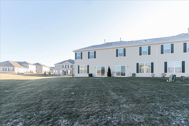 back of house featuring central AC and a yard