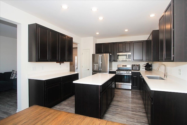 kitchen featuring sink, stainless steel appliances, light wood-type flooring, and a center island