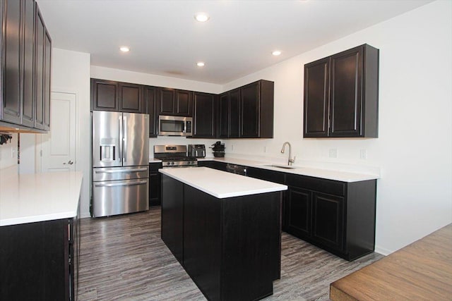 kitchen featuring a center island, stainless steel appliances, dark hardwood / wood-style flooring, dark brown cabinets, and sink