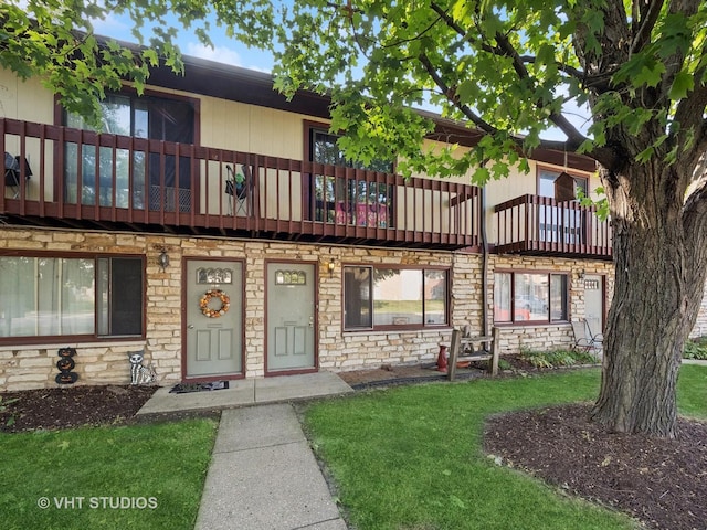 view of front of property with a balcony and a front yard