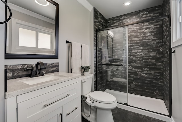 bathroom with crown molding, vanity, toilet, and a shower with door