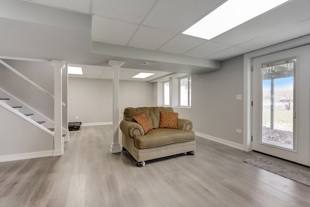 living room featuring a drop ceiling and light wood-type flooring