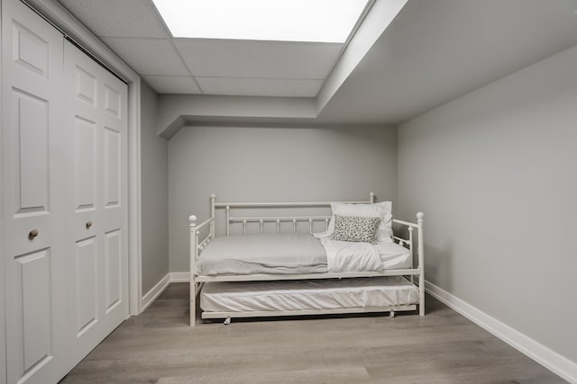 bedroom featuring wood-type flooring and a drop ceiling