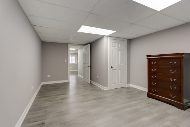 interior space featuring a paneled ceiling and light hardwood / wood-style flooring