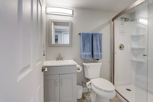 bathroom with vanity, toilet, and a shower with shower door