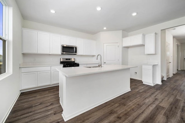 kitchen with stainless steel appliances, a center island with sink, white cabinets, and sink