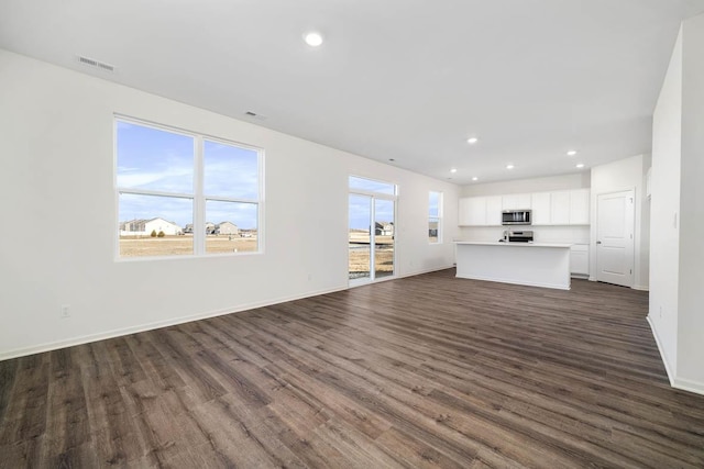 unfurnished living room with dark hardwood / wood-style flooring