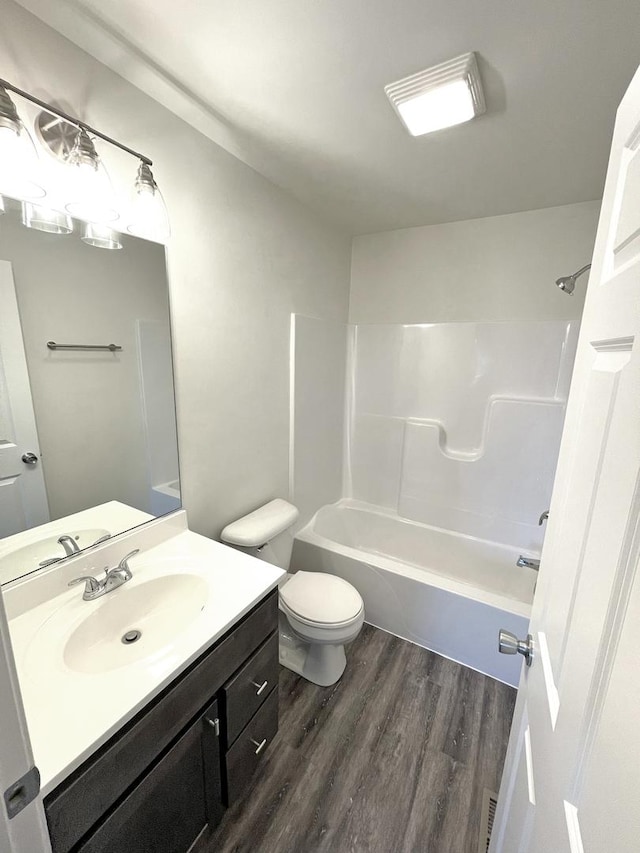 full bathroom with wood-type flooring, toilet, shower / bath combination, and vanity