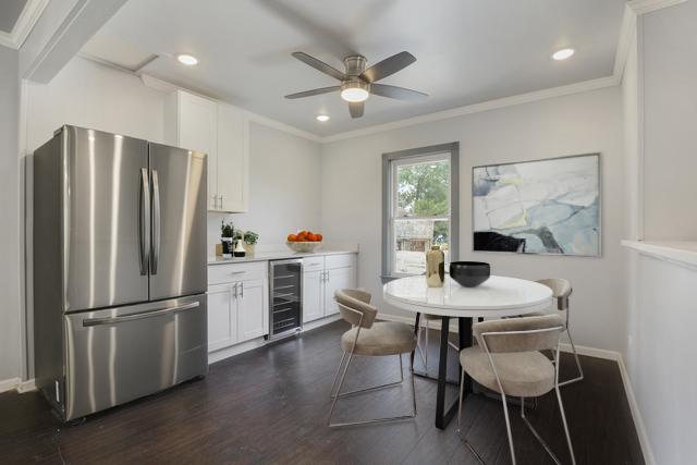 dining area featuring ceiling fan, dark hardwood / wood-style flooring, beverage cooler, and crown molding