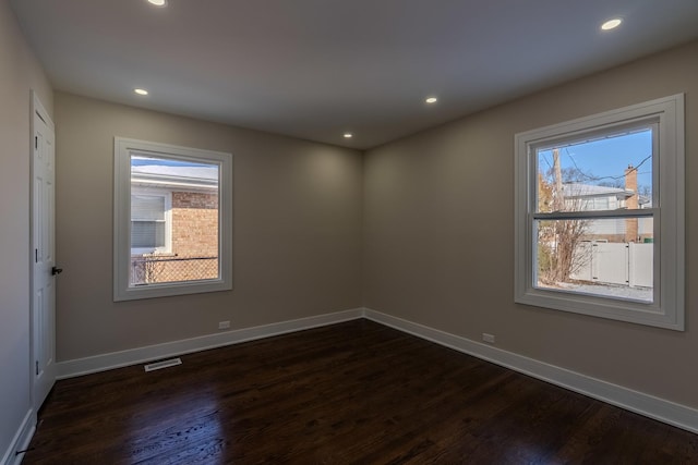 unfurnished room with dark wood-type flooring