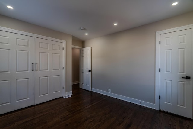 unfurnished bedroom with a closet and dark hardwood / wood-style floors