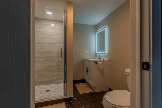 bathroom featuring toilet, an enclosed shower, and vanity