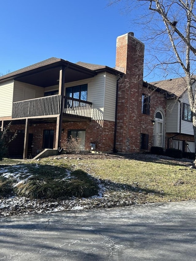 snow covered property featuring a balcony and a yard