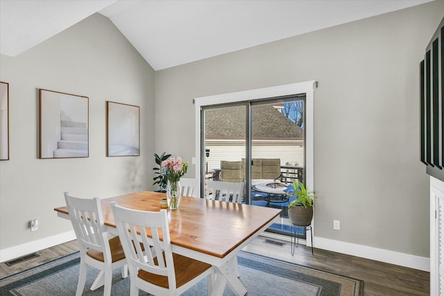 dining area with dark wood-type flooring and lofted ceiling