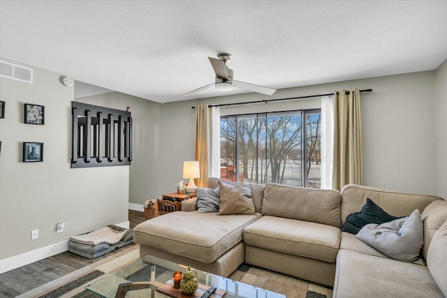 living room with ceiling fan, a textured ceiling, and hardwood / wood-style floors