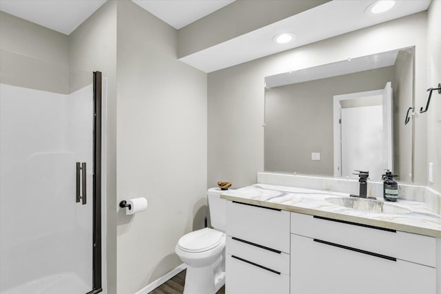 bathroom featuring walk in shower, vanity, toilet, and hardwood / wood-style flooring