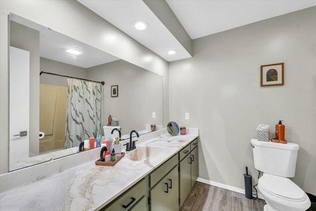 bathroom with toilet, hardwood / wood-style floors, vanity, and curtained shower