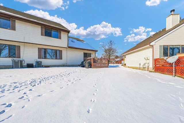 rear view of property featuring central air condition unit and a wooden deck