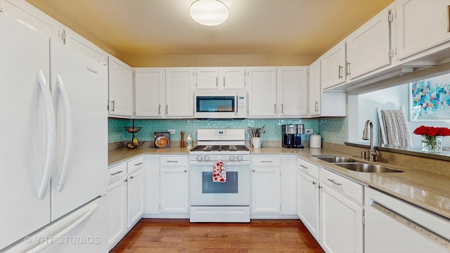 kitchen with white cabinetry, sink, and white appliances