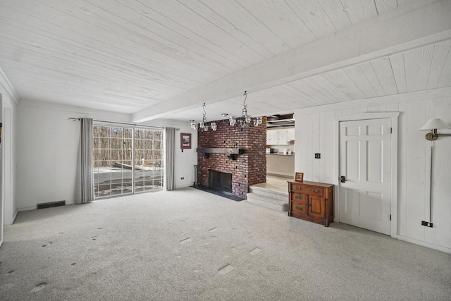 unfurnished living room featuring beamed ceiling, carpet floors, and a fireplace