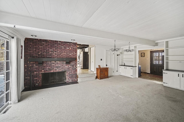 unfurnished living room with a fireplace, carpet, beam ceiling, and a wealth of natural light