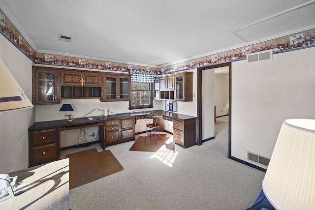 kitchen featuring dark brown cabinetry, built in desk, ornamental molding, and light carpet