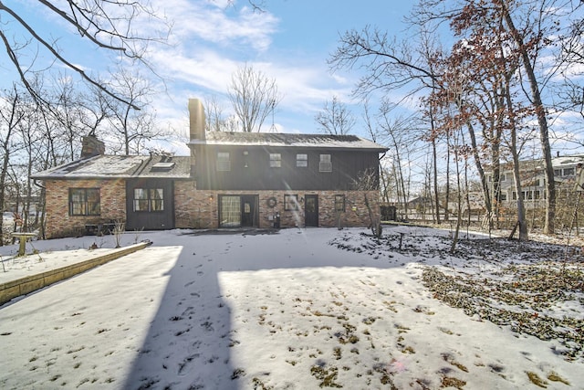 view of snow covered back of property