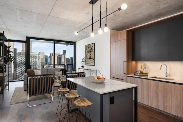 kitchen featuring pendant lighting, sink, dark hardwood / wood-style floors, and a kitchen island