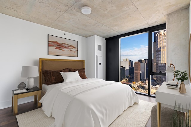 bedroom with hardwood / wood-style floors and expansive windows