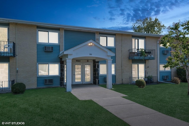 townhome / multi-family property featuring french doors, a balcony, and a front lawn