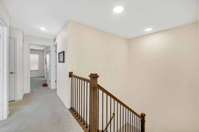 hallway featuring light colored carpet