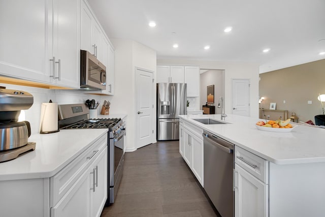 kitchen featuring an island with sink, stainless steel appliances, decorative backsplash, white cabinets, and sink