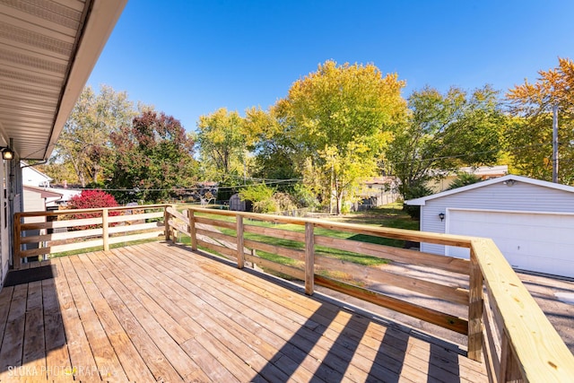 deck with a garage, an outdoor structure, and a lawn