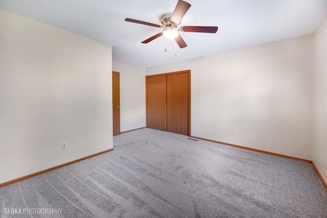 unfurnished bedroom featuring ceiling fan, a closet, and light carpet