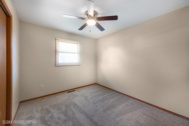 carpeted spare room featuring ceiling fan