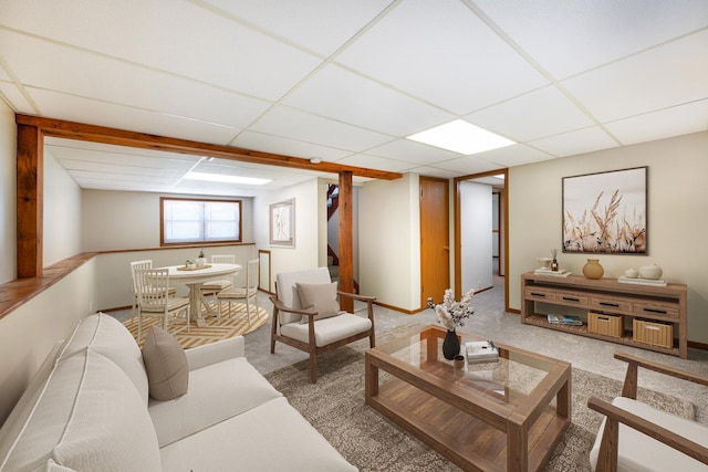 carpeted living room featuring a drop ceiling