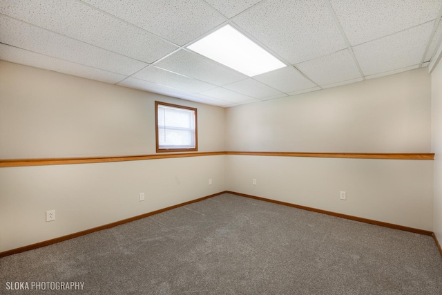 carpeted spare room with a drop ceiling